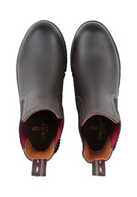 Brązowe skórzane buty wsuwane z okrągłym czubkiem, teksturowaną powierzchnią, burgundową wyściółką wewnętrzną oraz kontrastującymi detalami szycia.