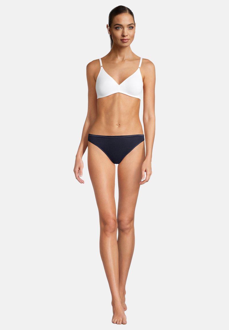 Weißes Bustier mit dünnen Trägern und einem navy-blauen Bikini-Oberteil. Glattes Material, einfaches Design und angenehme Passform.