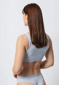 Grau sportlicher BH und passender Slip, gefertigt aus weichem Material mit glatter Textur. Verfügt über einen breiten Bund und ein einfaches Design, ohne Muster oder Akzente.