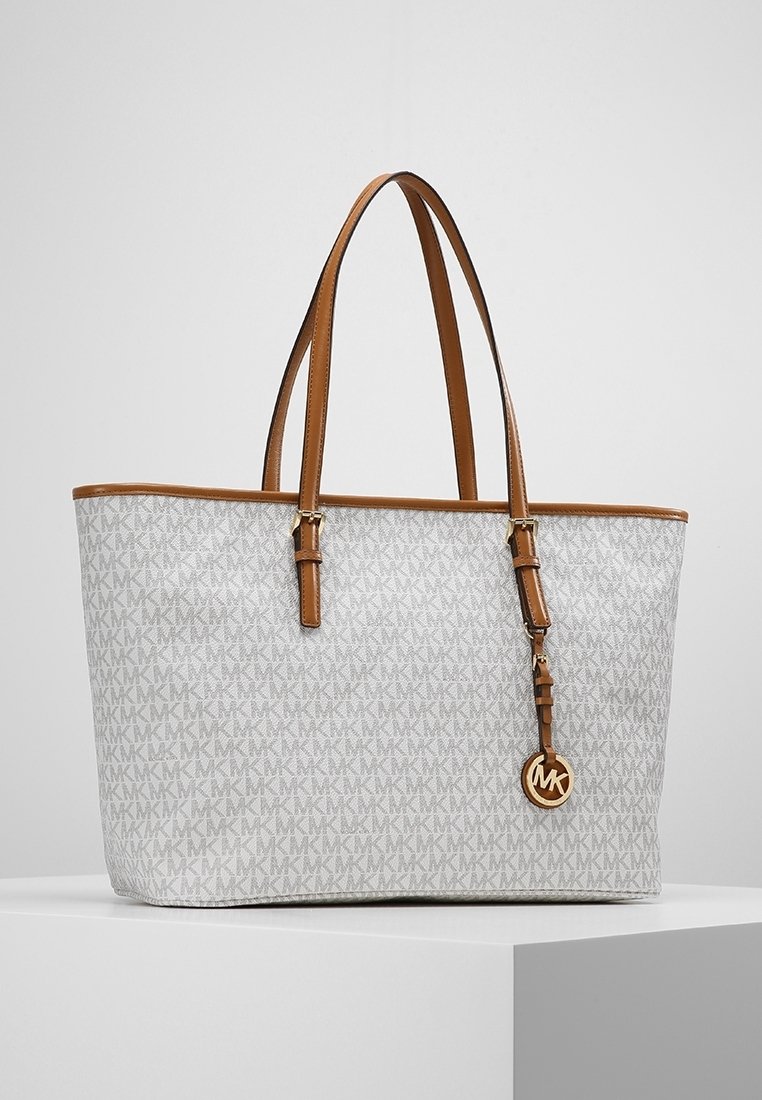 Große Tote-Tasche mit einem hellgrauen Monogrammmuster, hellbraunen Ledergriffen und einem goldfarbenen Logo-Anhänger. Glatte Textur und strukturierte Form.