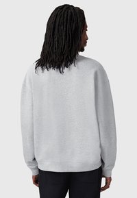 Szary sweter z luźnym krojem, wykonany z miękkiego materiału. Posiada ściągacze przy mankietach i u dołu oraz klasyczny dekolt typu crew neck.