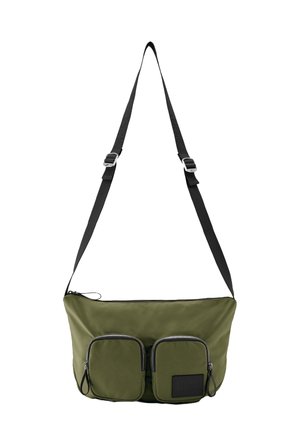 Olivgrüne Crossbody-Tasche mit verstellbarem schwarzem Gurt, zwei vorderen Reißverschlusstaschen und schwarzem Logo-Patch an einer Tasche.
