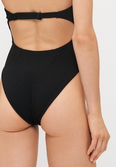 Musthave mustribu, millel lõikamispaiga disain. Sile kangas, minimalistisch välimus ja sujuv viimistlus.