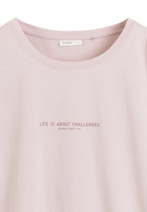 Jasnoróżowa koszulka z okrągłym dekoltem i tekstem "LIFE IS ABOUT CHALLENGES" oraz "ATLANTIC SINCE 1994" wydrukowanym wielkimi literami.