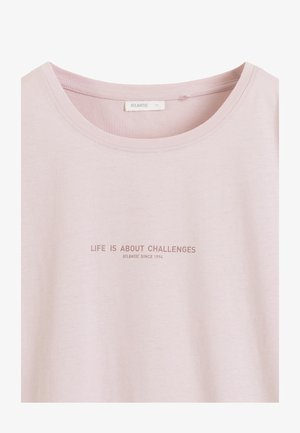 Jasnoróżowa koszulka z okrągłym dekoltem i tekstem "LIFE IS ABOUT CHALLENGES" oraz "ATLANTIC SINCE 1994" wydrukowanym wielkimi literami.