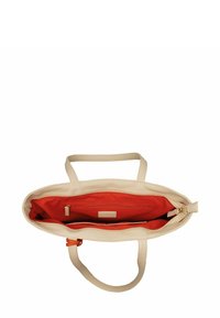 Sac fourre-tout en cuir beige avec un dessus ouvert, un intérieur orange, deux poignées et une poche zippée. Texture lisse et matériel minimal.