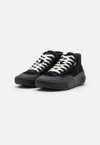 Svart semsket høy-topp sneakers med hvite snører, gummierte svarte såler og kontrastsøm. Har en teksturert tåhette og slitesterk design.