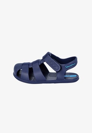 Sandalia de dedo cerrada azul marino con correas ajustables, suela texturizada y logo "Ipanema" en azul claro en la correa del talón.