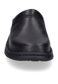 Black leather slip-on shoe with a curved toe, textured surface, and stitching along the upper edge. Flat rubber sole visible below.