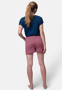 Marineblauwe, kortmouwige, geribbelde top gecombineerd met rozenkleurige, elastische taille, ademende shorts. Soepele textuur; casual ontwerp.