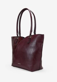 Bolso tote de cuero burdeos con texturas suaves y en relieve, que cuenta con dos asas y una sutil marca. Forma alargada con un diseño estructurado.