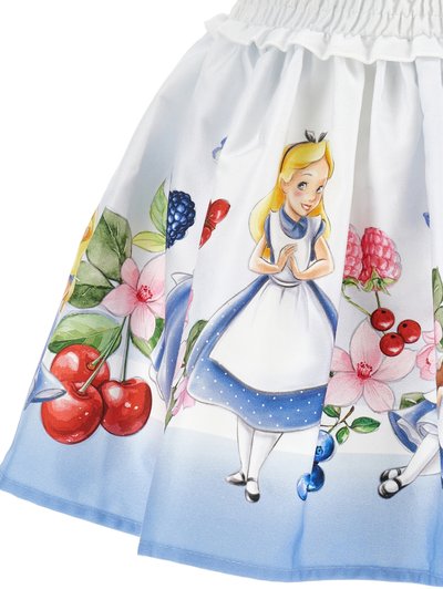 Blå og hvit stoffet skjørt med illustrasjon av en jente med blondt hår, omgitt av frukt- og blomster mønstre. Volangdetalj i midjen.