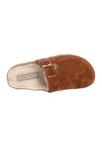 Brown suede slip-on clog with adjustable metal buckle and soft cream-colored fleece lining inside.