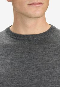 Grå crew-neck tröja med en slät textur och ribbad krage, som visar närbild av tyget utan mönster eller accenter.