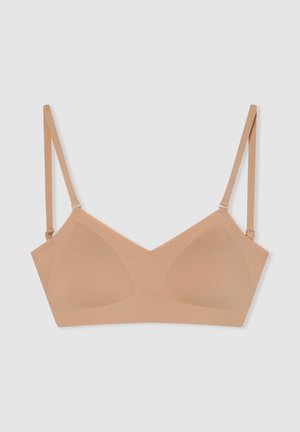 Reggiseno wireless nudo con tessuto liscio, coppe triangolari, spalline regolabili e design minimalista. Senza ferretto o decorazioni aggiuntive.
