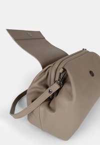 Borsa a tracolla in pelle beige con corpo struttura, chiusura a pattina superiore e una corta tracolla. Presenta cuciture sottili e un bottone a pressione metallico.