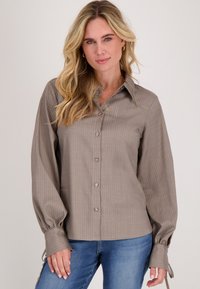 Grijs gestreept overhemd met lange mouwen en manchetstrikjes, gemaakt van een gladde stof. Draag het met blauwe spijkerbroeken.