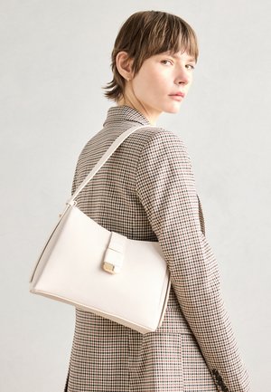 Bela usnjena torba s strukturirano zasnovo, opremljena z magnetnim zapiranjem in naramnico, prikazana na nevtralni ozadju.