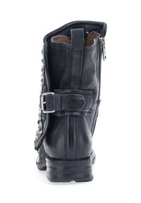 Čierna kožená členková obuv so štruktúrovaným povrchom, ktorá má zips, ozdobný pracku a kovové cvoky na boku.