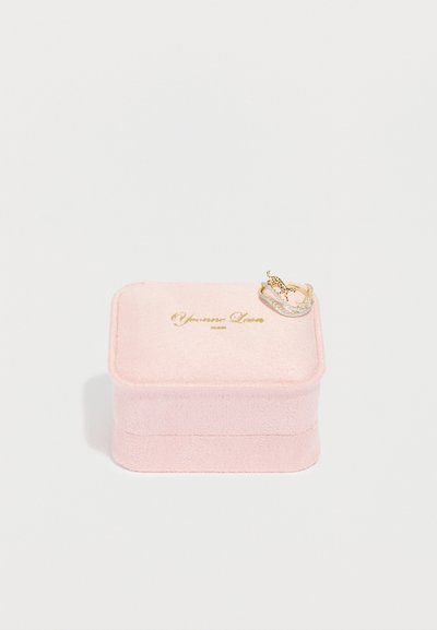 Ροζ βελούδινο κουτί κοσμημάτων με χρυσά γράμματα στο καπάκι. Περιέχει ένα διακοσμητικό δαχτυλίδι με καμπυλωτό σχέδιο, που διαθέτει συνδυασμό χρυσών και ασημένιων διακοσμήσεων.