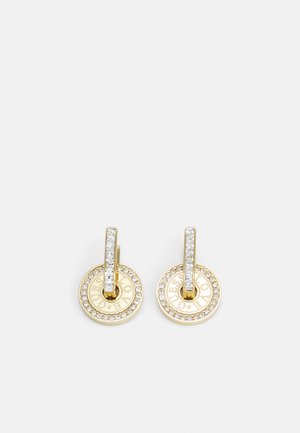 Boucles d'oreilles en or ornées de disques circulaires avec une surface texturée, entourés de petits cristaux transparents, et d'une tige droite rehaussée de cristaux.
