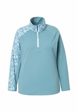 Suéter azul claro con media cremallera, que presenta un diseño blanco estampado en una manga. Está hecho de una tela suave y elástica.