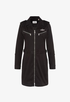 Abrigo de trench de algodón negro con cremallera frontal, dos bolsillos en el pecho con cremallera, hombreras y detalles de cintura con botones. Mangas largas y cuello.