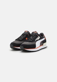 Sneakers neri in suede e rete con accenti bianchi, dettagli arancioni e suola in gomma testurizzata. Presentano un colletto imbottito e lacci sicuri.