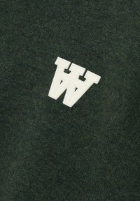 Dark green sweater fabric with a soft texture; features a white, raised, double 'W' logo stitched on the upper left side.