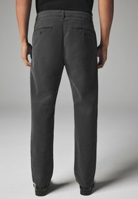 Dunkelgraue Chinos mit regulärer Passform, glatter Textur, zwei Gesäßtaschen mit Knöpfen und sichtbaren Gürtelschlaufen am Bund.
