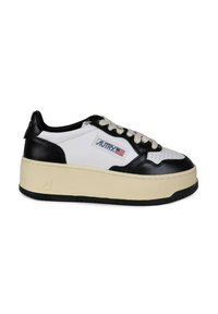 Sneaker in pelle bianca e nera con suola spessa crema, punta rotonda, perforazioni nella scatola della punta e una patch con il logo sul lato.