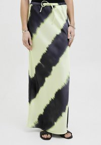 Maxi rok gemaakt van lichte stof, met een tie-dye patroon in zwart en fel limoen groen, met een elastische tailleband en trekkoord.
