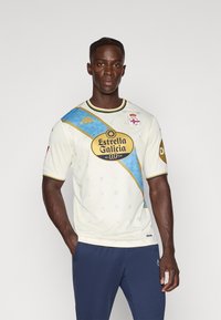 Bijela sportska majica s plavim i zlatnim dijagonalnim akcentima, s okruglim izrezom, kratkim rukavima i logotipom na sredini.