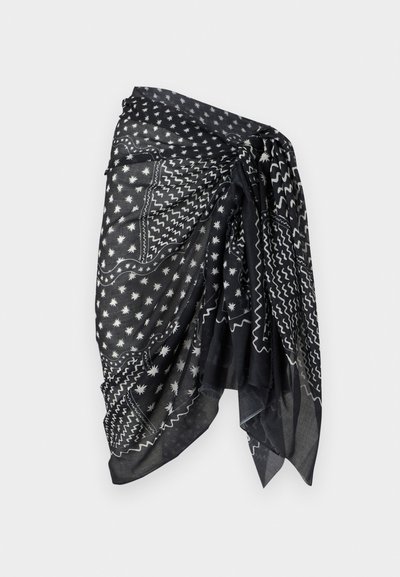 Μαύρο-άσπρο παρεό με σχέδια αστέρια και κυματιστές γραμμές, δεμένο στη μέση, ελαφρύ ύφασμα με ρέουσα υφή.