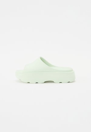 Mint green slip-on sandals with a smooth, matte surface and a chunky sole featuring a textured pattern for grip.