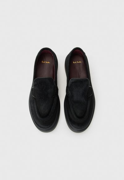 Scarpe slip-on nere realizzate in pelle con texture a pelo lungo e interno liscio. Presentano un design arrotondato e una suola imbottita.