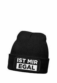 Black knit beanie with a ribbed texture. Features a rectangular patch displaying the text "IST MIR EGAL" in bold white letters.