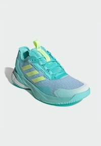 Turkusowy but sportowy z siateczkową cholewką, kontrastującymi żółtymi akcentami, wyściełanym kołnierzem i gumową podeszwą zaprojektowaną dla komfortu i przyczepności.