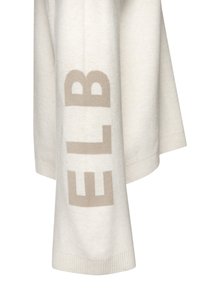 Crème gebreide trui met een zachte textuur en geribbelde manchetten, voorzien van grote taupe letters "ELB" die op de mouw zijn gedrukt.