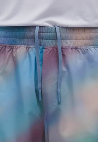 Shorts de tie-dye en tela suave con una cinturilla elástica, cordones de color azul claro y una mezcla de colores pastel que incluye azul, rosa y lavanda.