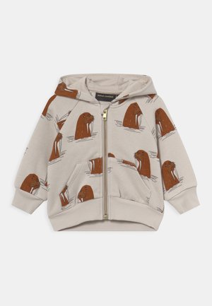 Beżowa bluza z kapturem zapinana na zamek, ozdobiona brązowym nadrukiem morsowania, z podszytym kapturem i przednimi kieszeniami. Wykończenie stanowią ściągacze na mankietach i na dole bluzy.