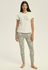 Cotton pajama set includes a white short-sleeve shirt with a ginkgo leaf print and light green pants with ginkgo patterns. Smooth texture.