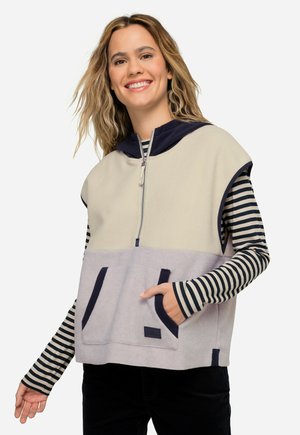 Pull à capuche en polaire beige et lavande, avec fermeture éclair, grande poche avant et manches longues rayées en noir et blanc.