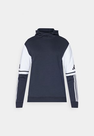 Marynarka w kolorze granatowym z białymi rękawami, wysokim kołnierzem i wzorem w trzy paski na rękawach. Wykonana z miękkiego materiału, charakteryzująca się luźnym krojem.