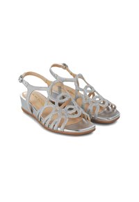 Sandalias plateadas con tacón y diseño recortado y acentos de purpurina. Presentan un pequeño tacón de cuña y una correa ajustable en el tobillo.