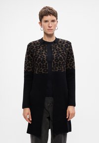 Sweter narzutowy z leopardzim wzorem w odcieniach brązu na czarnym tle, z okrągłym dekoltem i otwartym przodem.