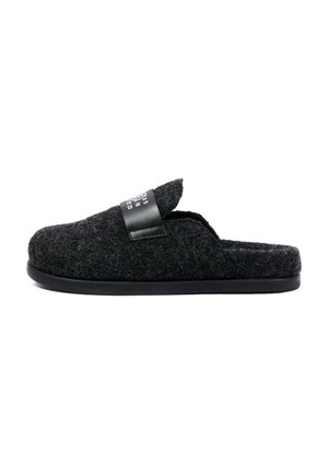 Pantofole nere in feltro slip-on con suola piatta e una piccola fascia nera in pelle sul lato superiore.
