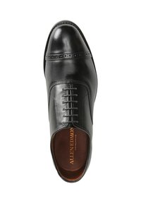Zwarte lederen oxford schoen met een gladde afwerking, ronde neus, smalle vetersluiting aan de voorkant en decoratieve perforaties nabij de zool.
