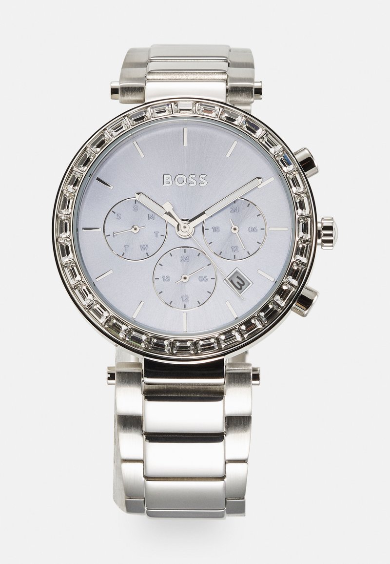 Silver stainless steel watch with a light blue dial, crystal-studded bezel, and three subdials; features a date window and polished finish.