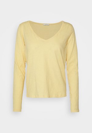 Camiseta de manga larga y escote en V en amarillo claro, confeccionada en una suave tela texturizada con un corte relajado y dobladillo cosido.